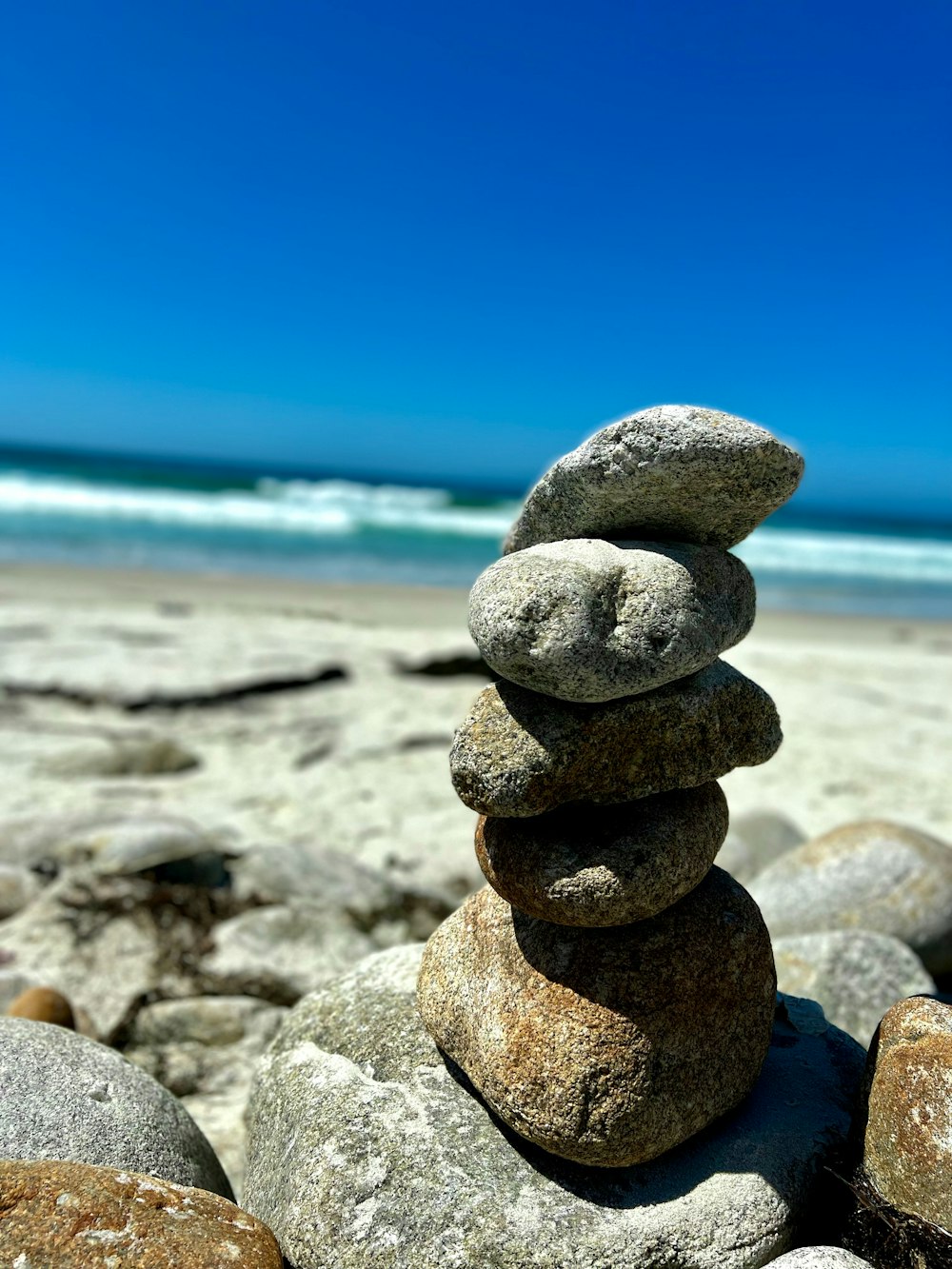 a stack of rocks sitting on top of a sandy beach