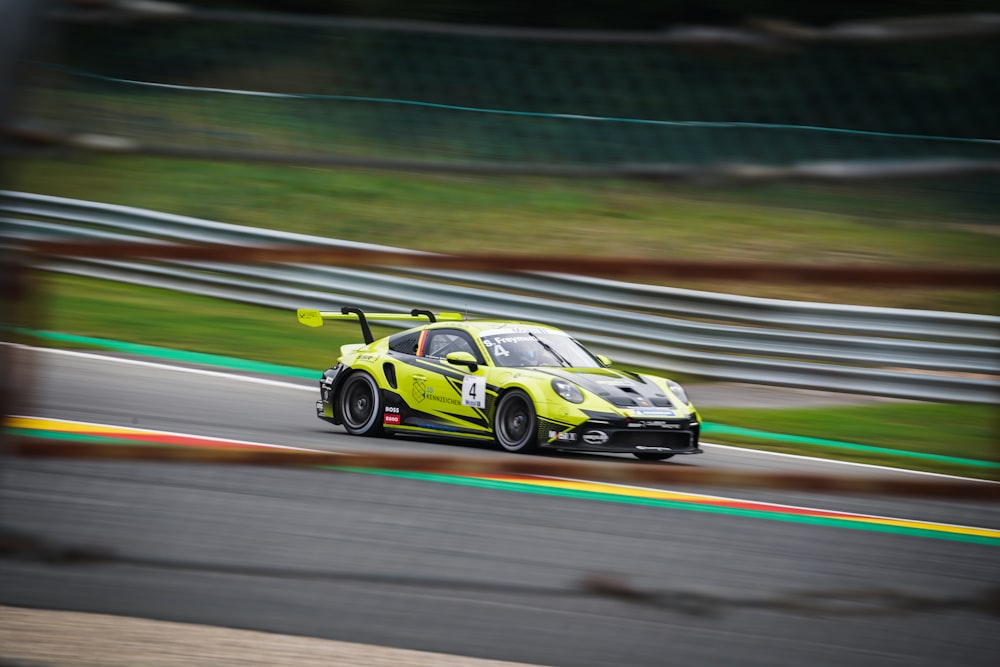 a yellow race car driving down a race track