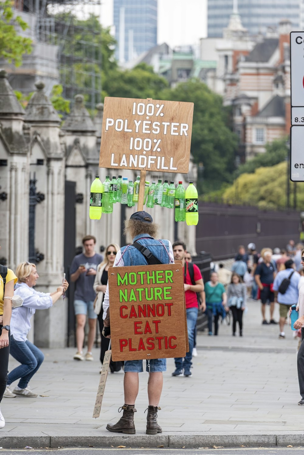a man holding a sign that says mother nature cannot eat plastic