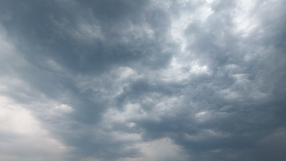 Eine Gruppe von Menschen, die auf einem Strand unter einem bewölkten Himmel stehen