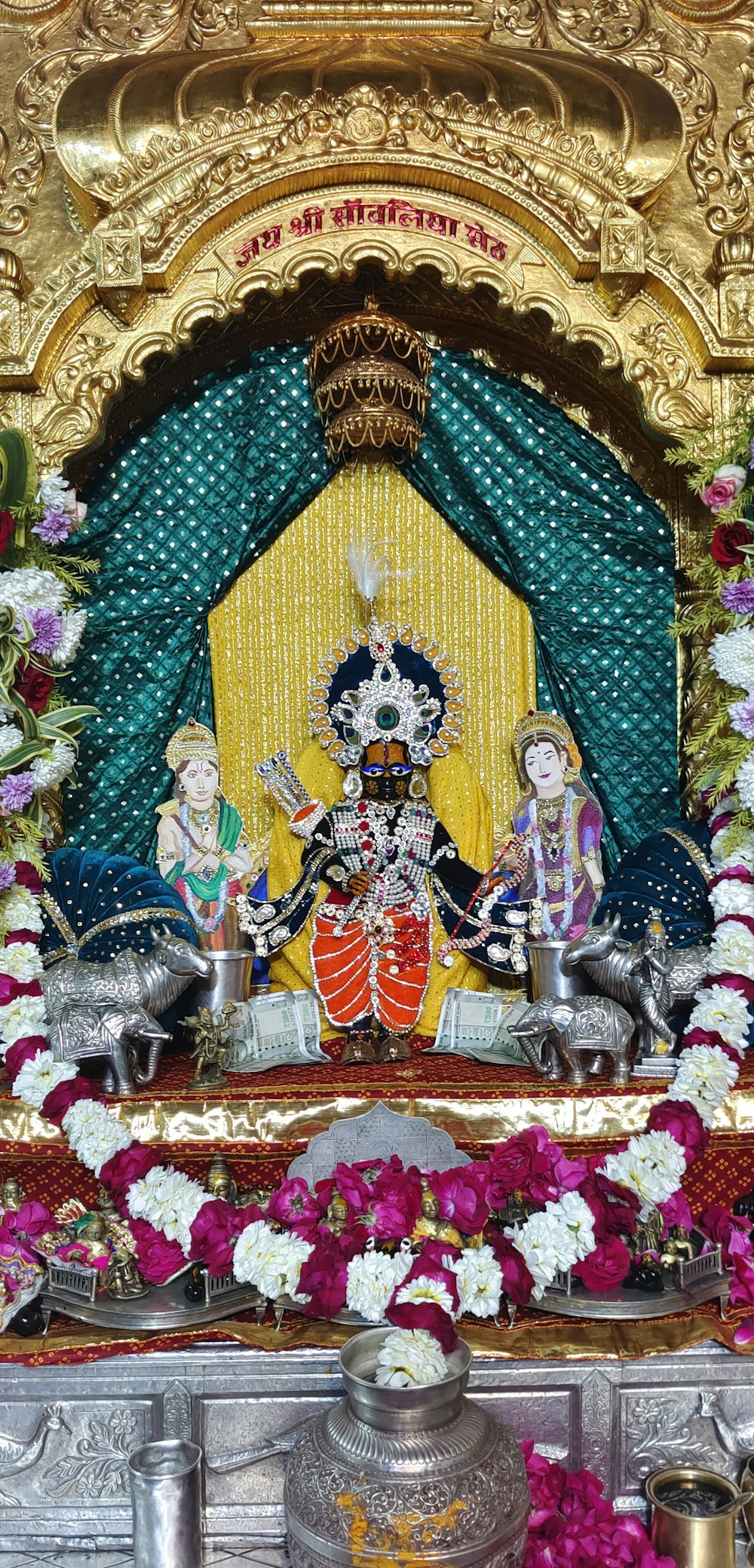 a decorated stage with flowers and a statue