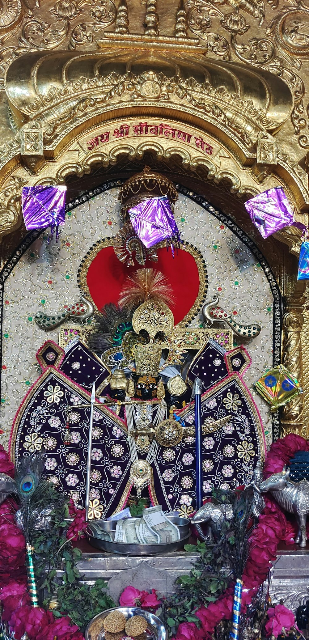 a shrine with a statue of a person surrounded by flowers