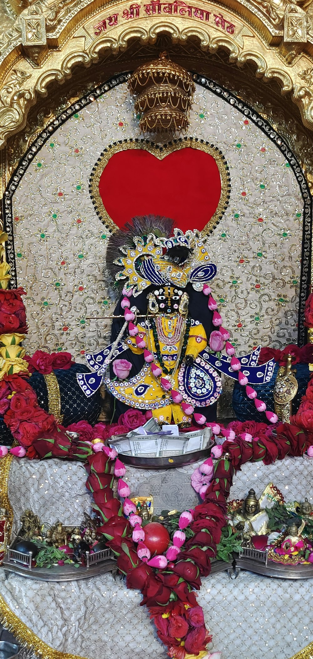 Uma estátua de um deus hindu cercada por flores