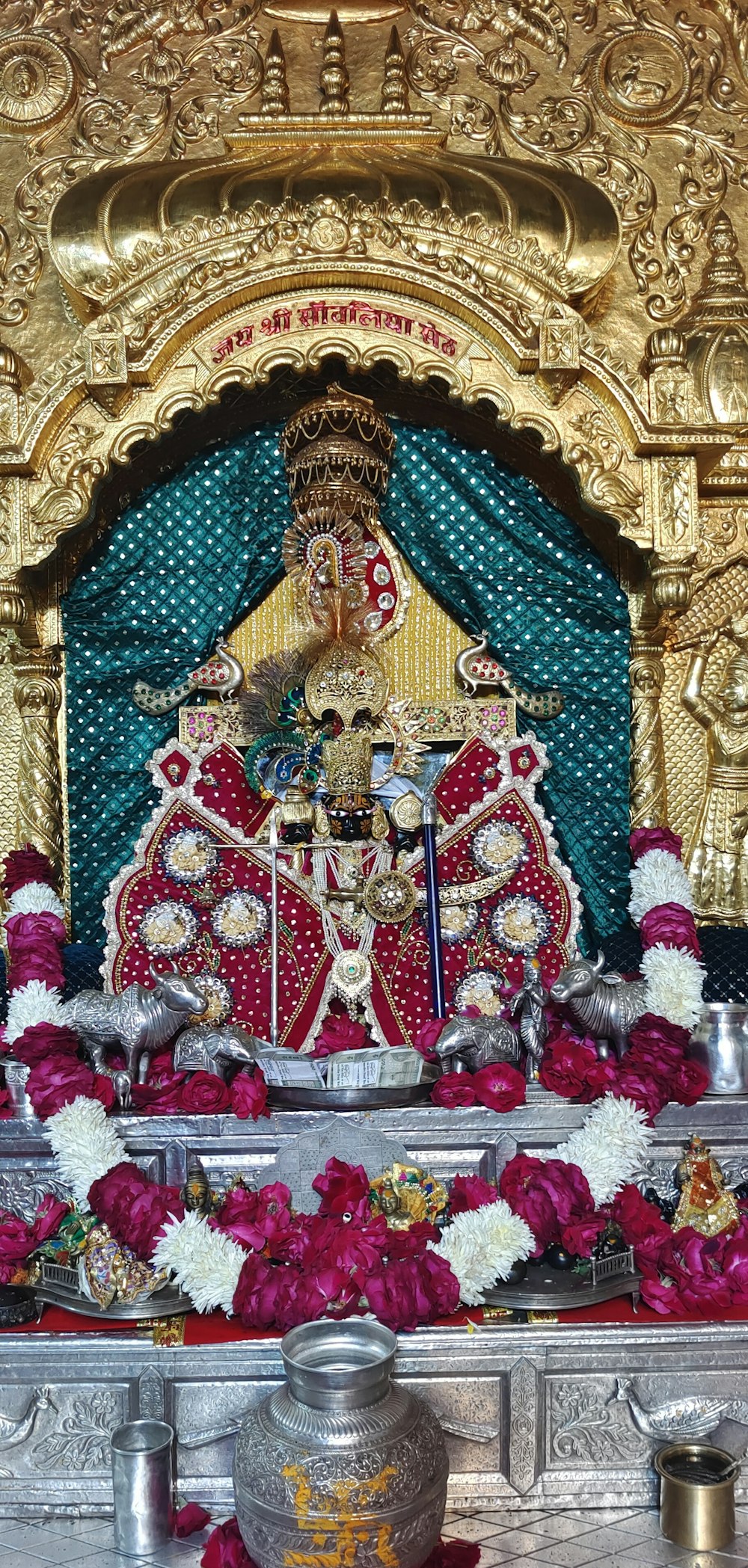 a shrine with a statue of a person surrounded by flowers