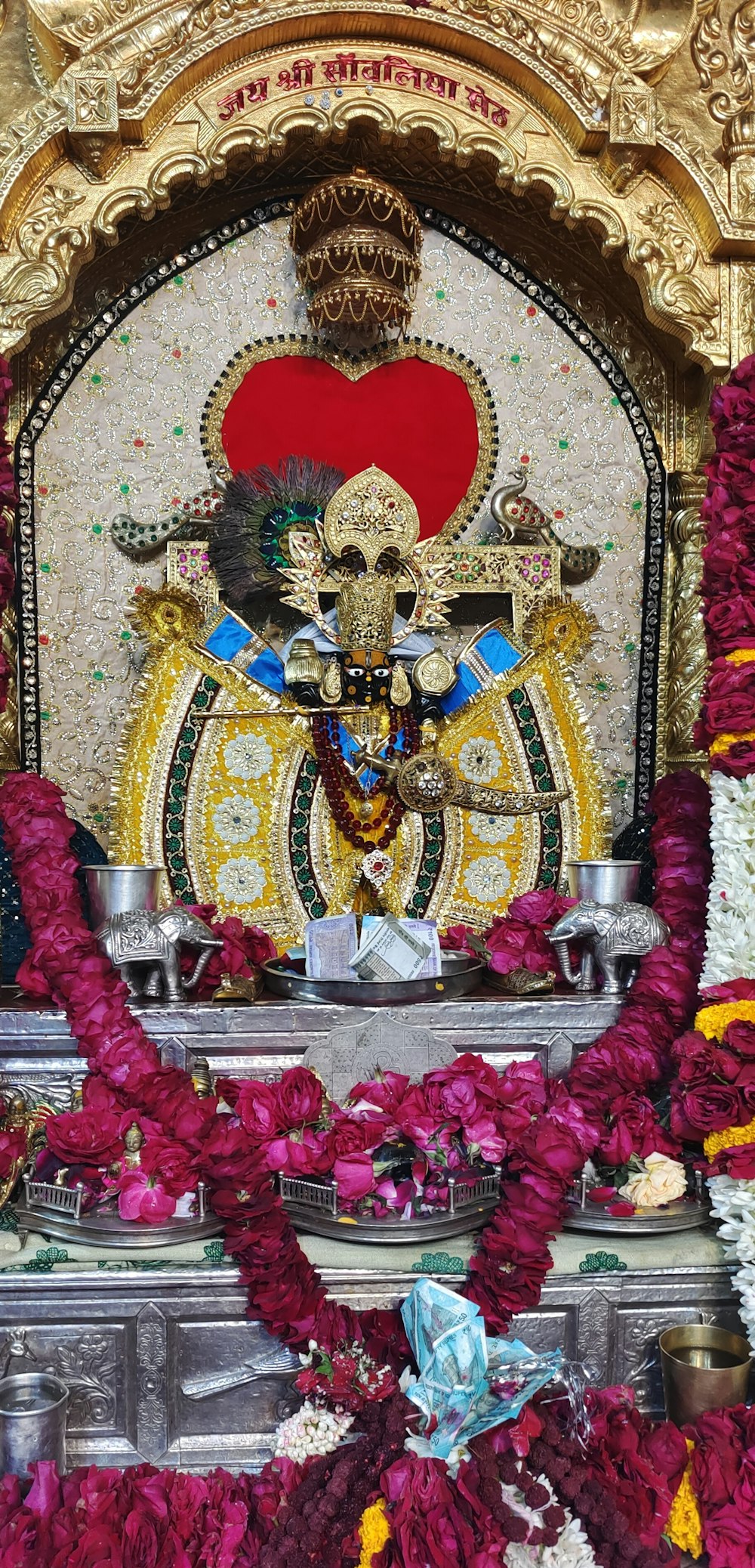 a statue of a god surrounded by flowers