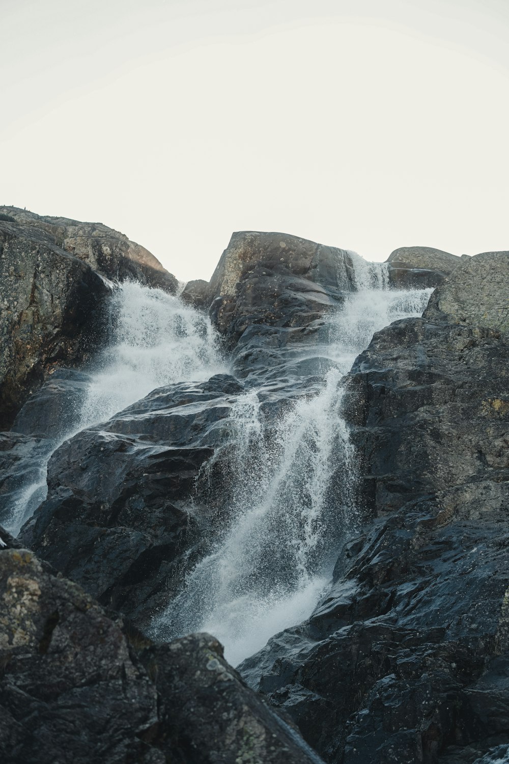 a man standing on top of a large waterfall