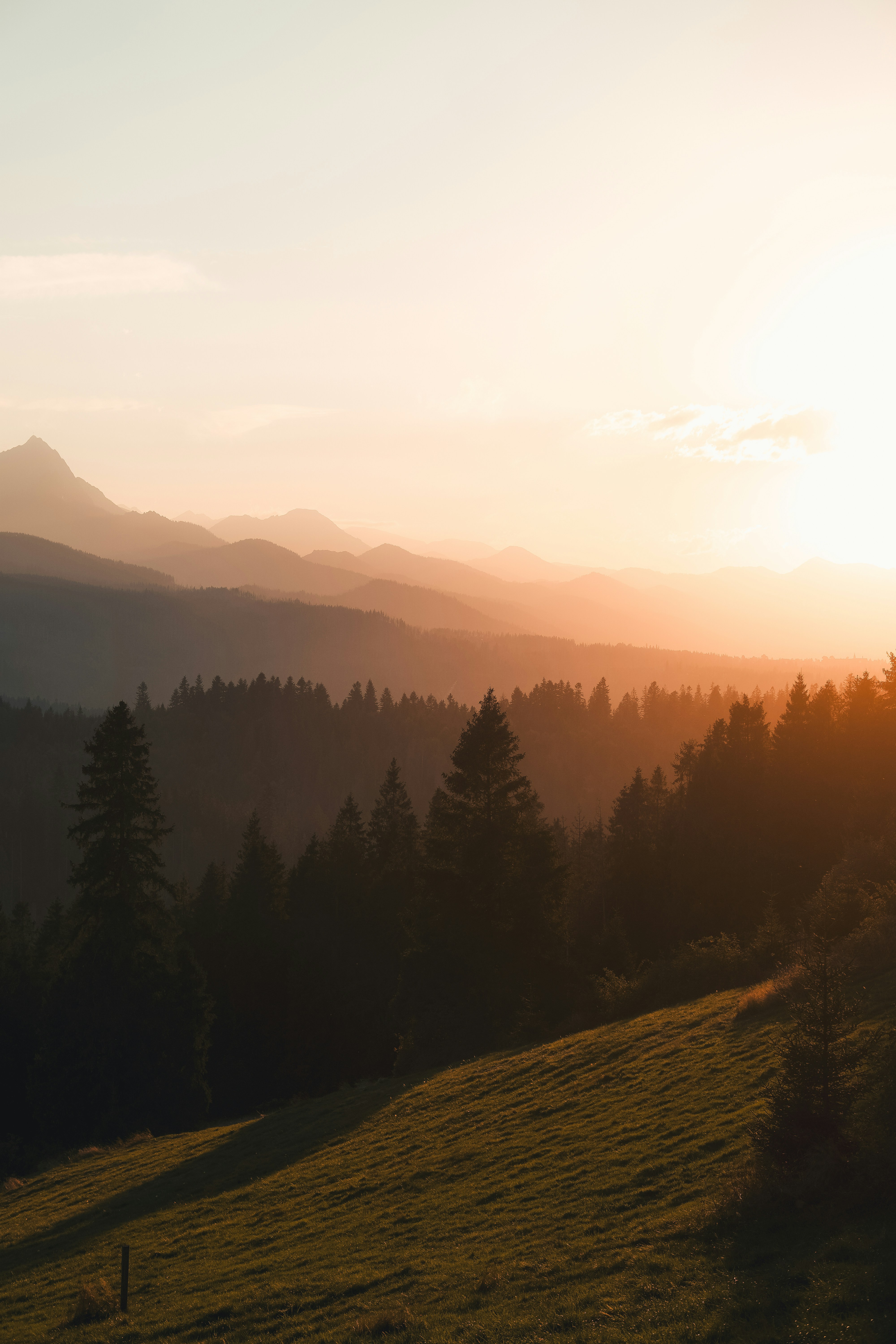 the sun is setting over the mountains in the distance