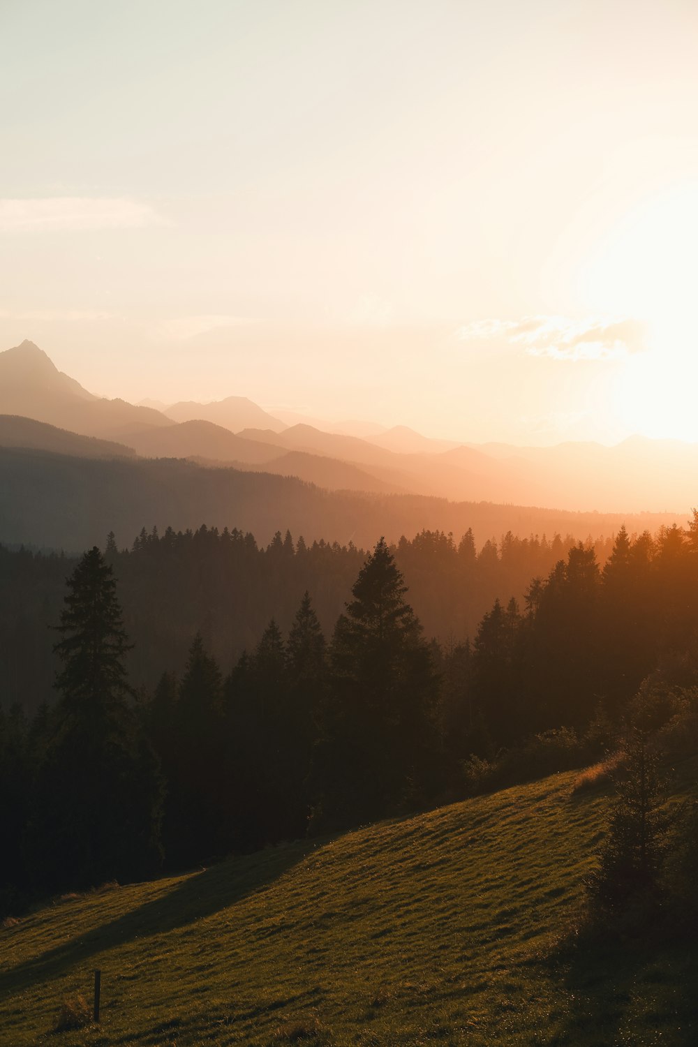 the sun is setting over the mountains in the distance