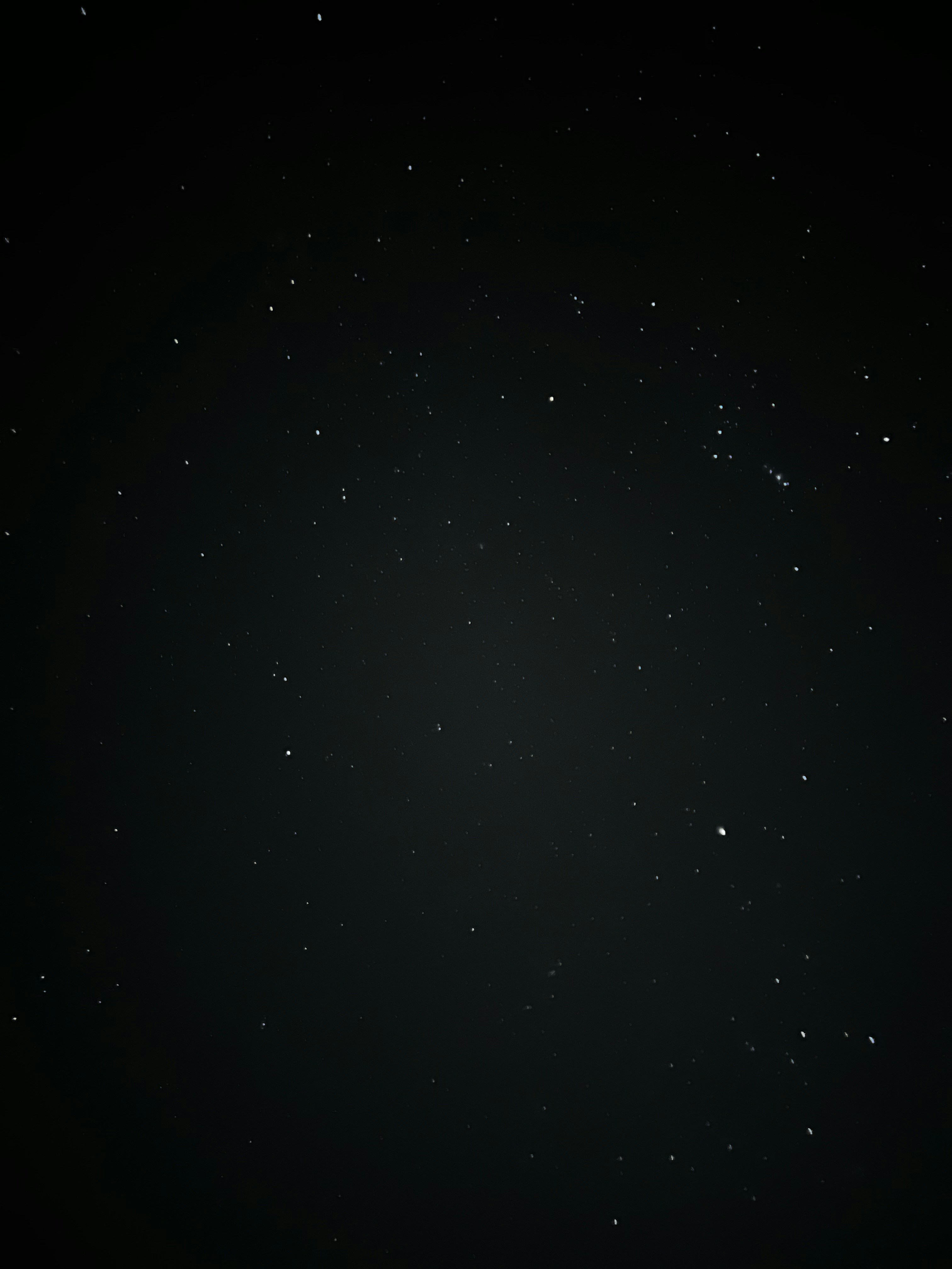 Dark night sky with extremely faint distant stars, near-black atmospheric environment, deep shadow, minimal ambient light