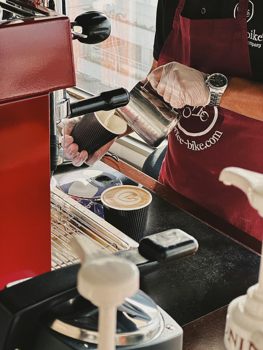 a person pouring a cup of coffee into a cup