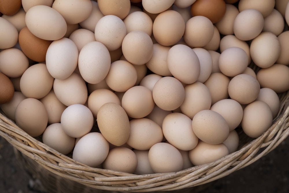 a basket filled with lots of brown and white eggs