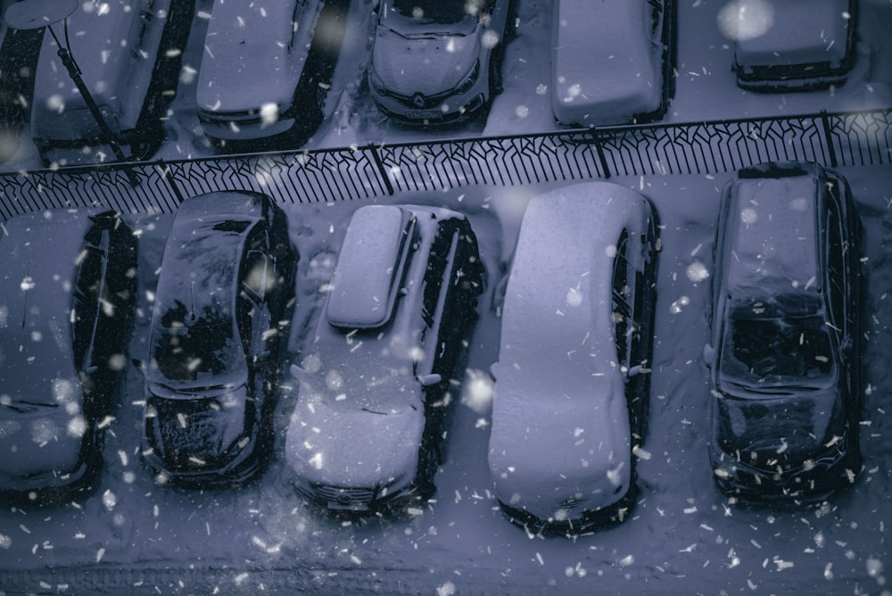 a parking lot filled with lots of cars covered in snow