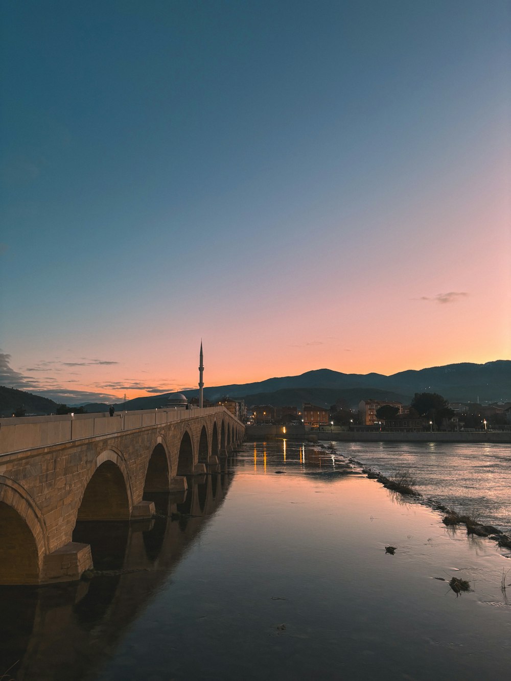 a bridge over a body of water at sunset