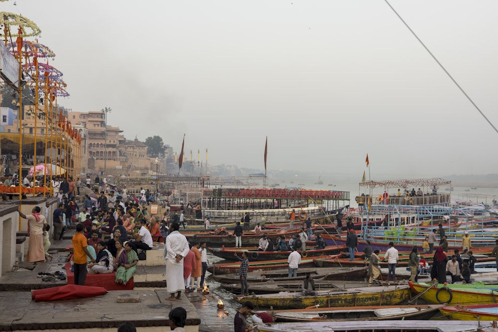 a group of people standing around a harbor filled with boats