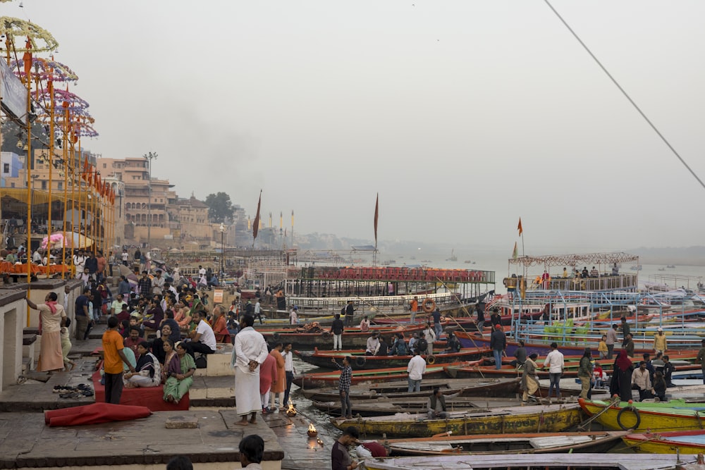 Un groupe de personnes debout autour d’un port rempli de bateaux