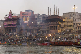 a group of boats floating on top of a river next to tall buildings