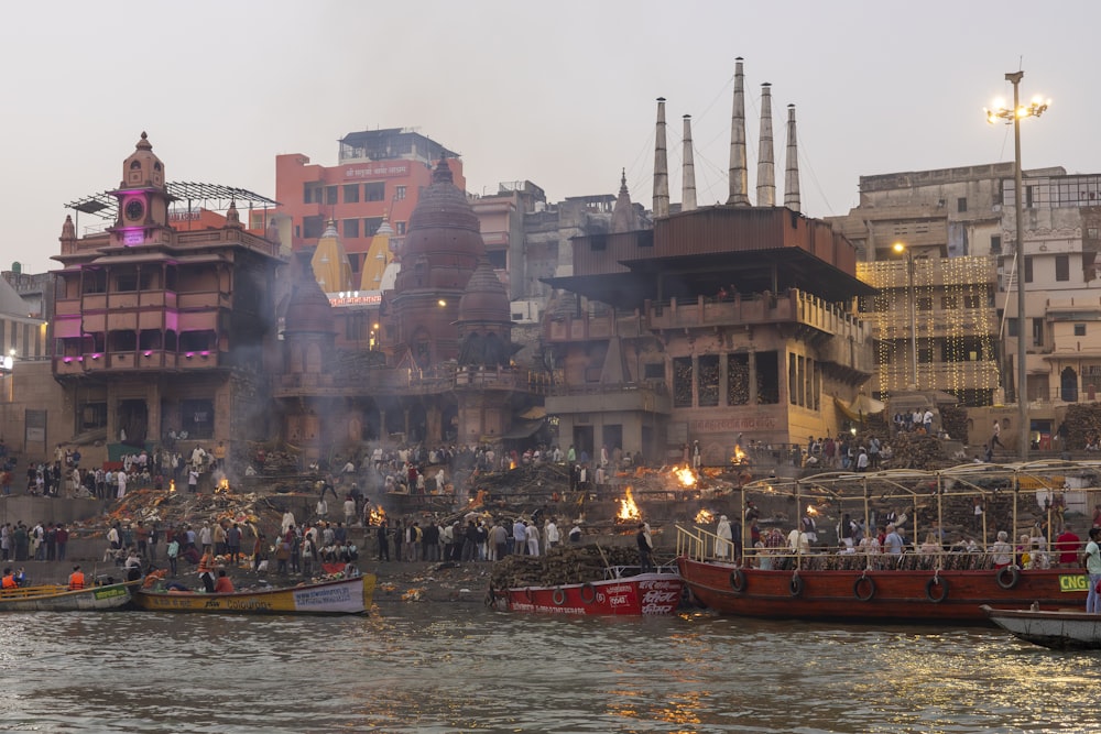a group of boats floating on top of a river next to tall buildings