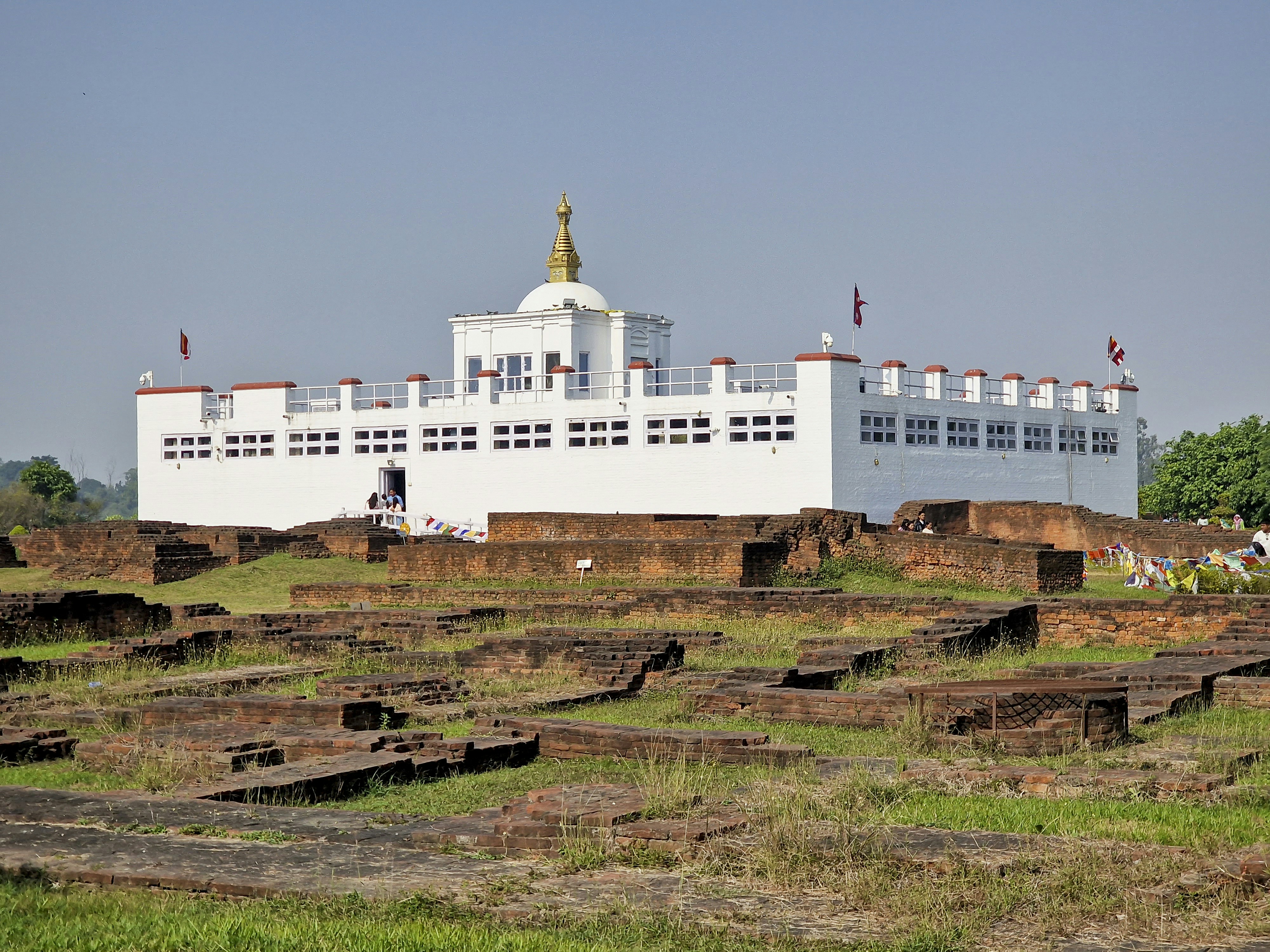 a large white building sitting on top of a lush green field