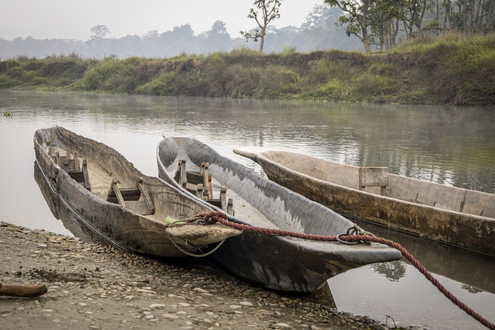 a couple of boats sitting on top of a river