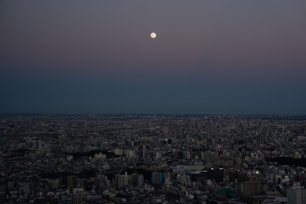 a full moon over a city at night