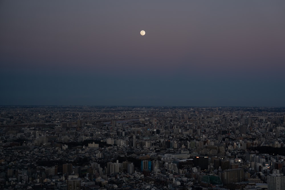 una luna llena sobre una ciudad por la noche
