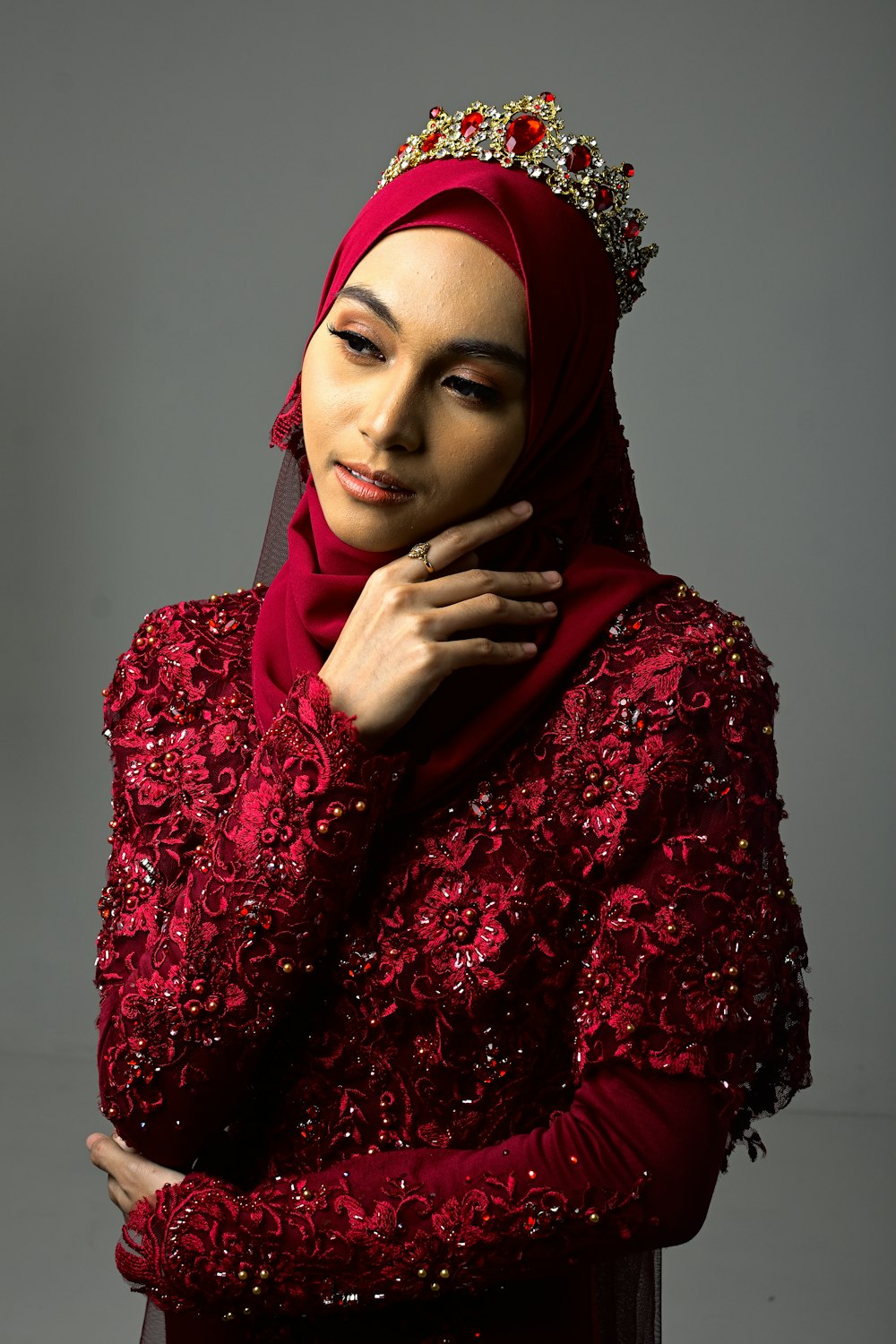 a woman wearing a red hijab and a tiara