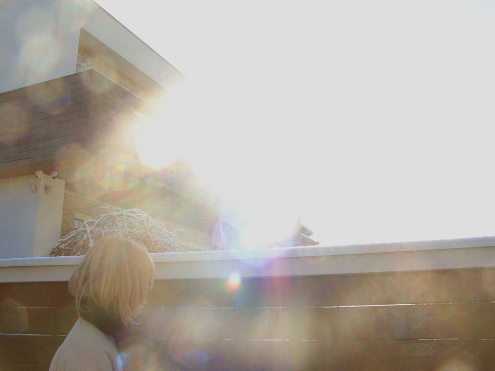 a woman standing on top of a roof next to a building