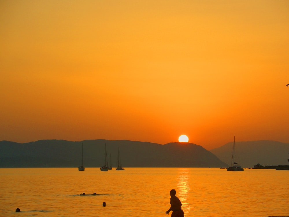 a person walking on the beach at sunset