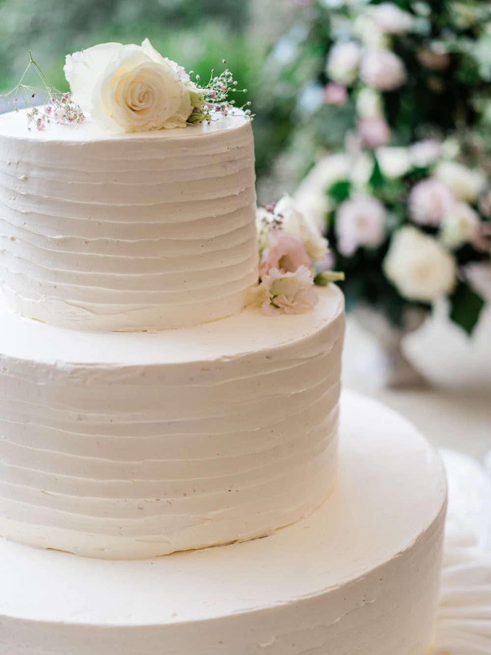 A white wedding cake with flowers on top