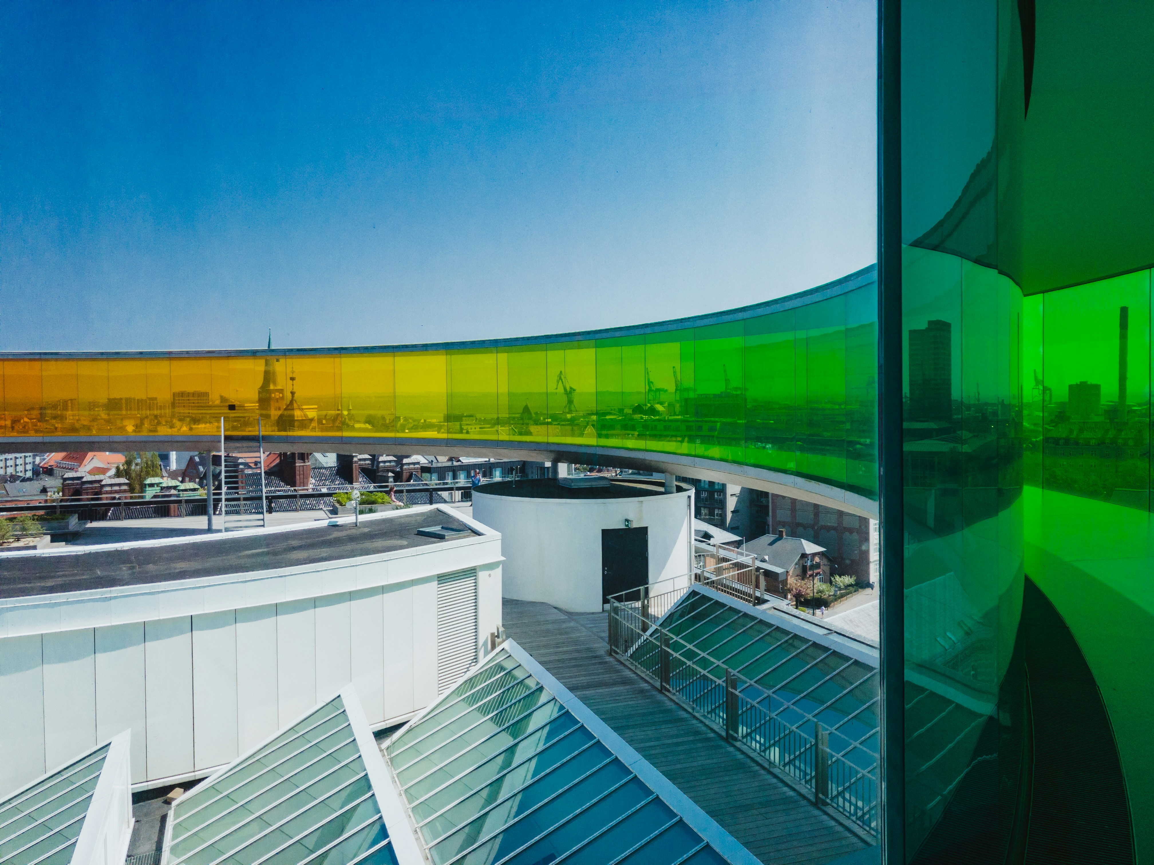 a building with a curved roof and green glass