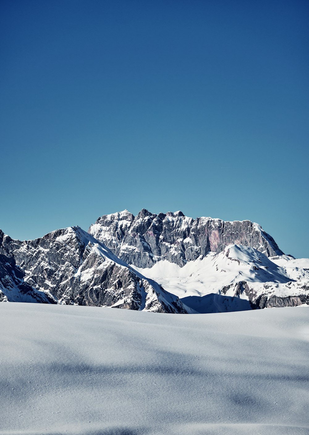 a person on skis in the snow with mountains in the background