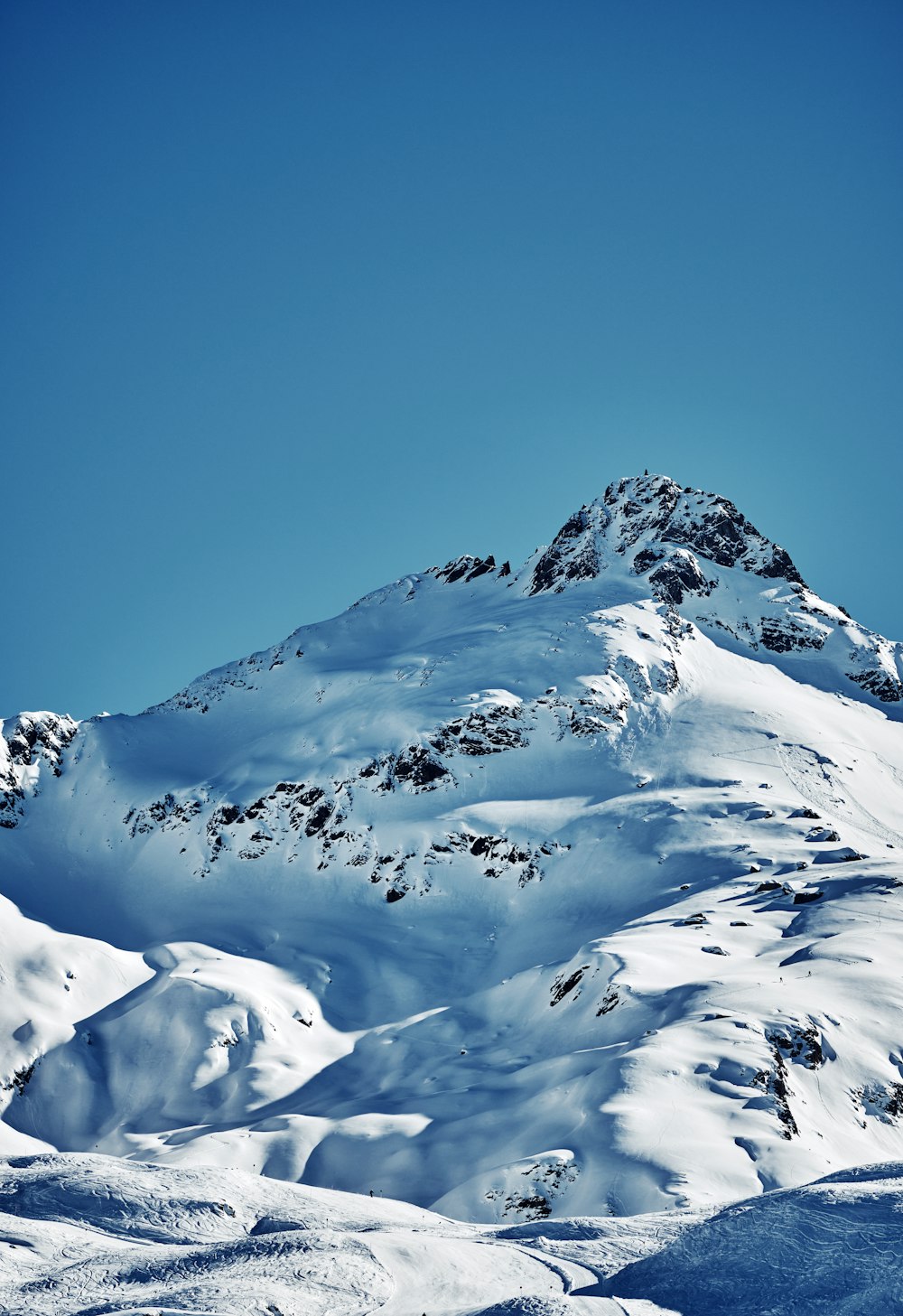 a mountain covered in snow under a blue sky