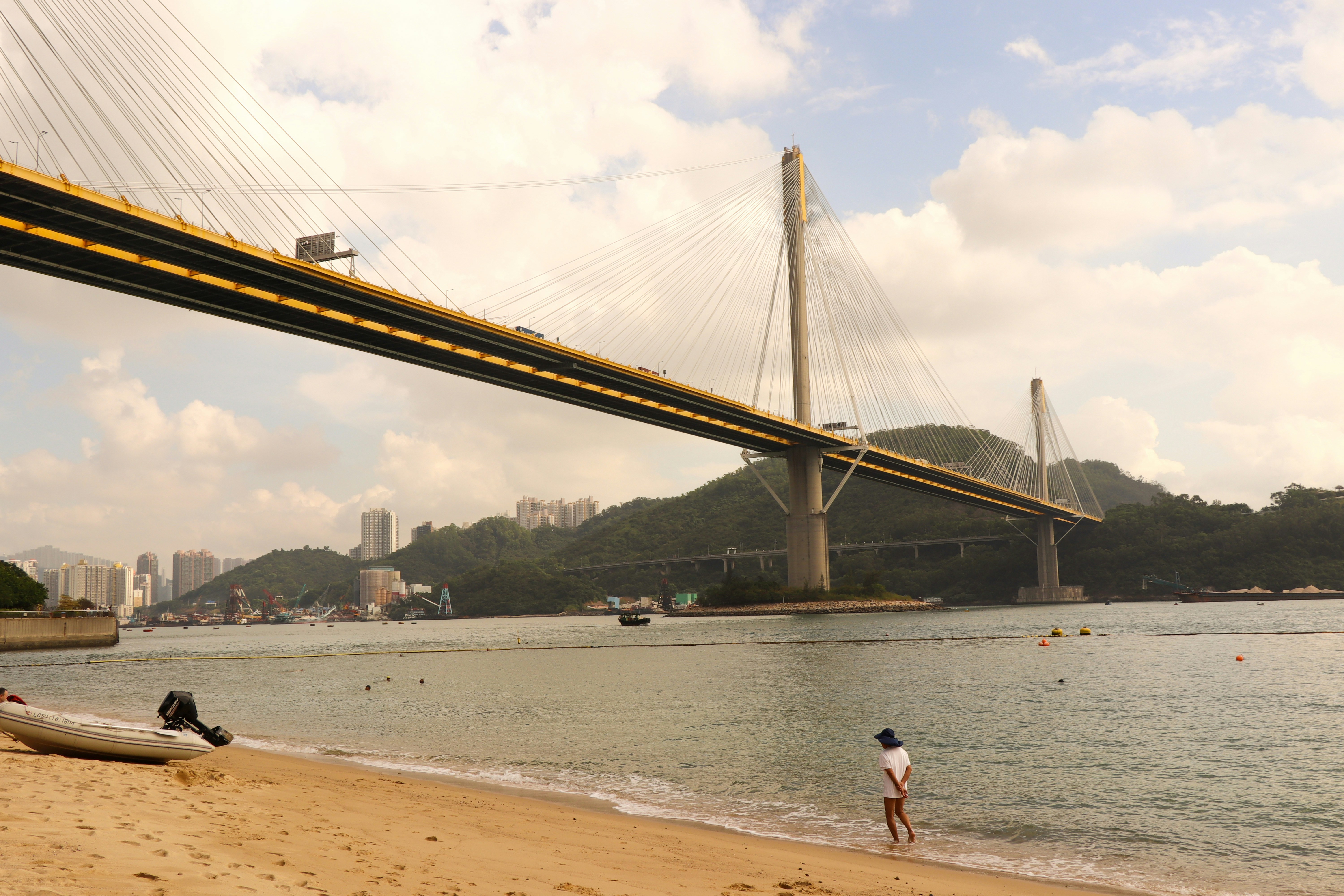 a man standing on a beach next to a boat