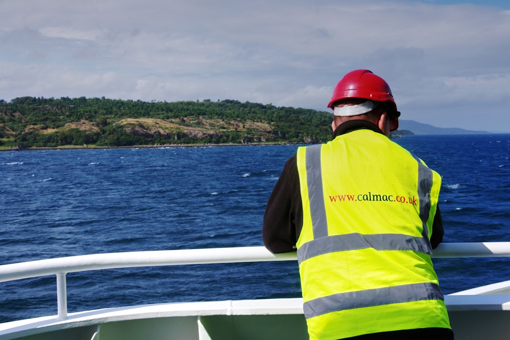 a man in a safety vest standing on a boat