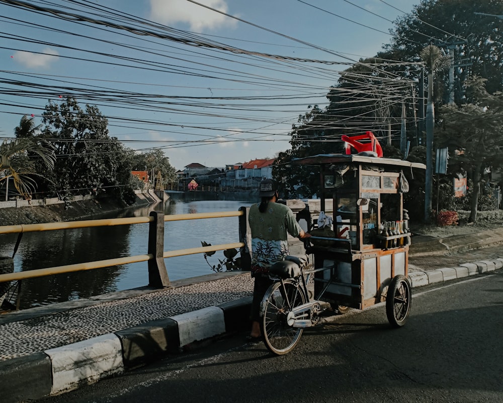 a man riding a bike next to a body of water