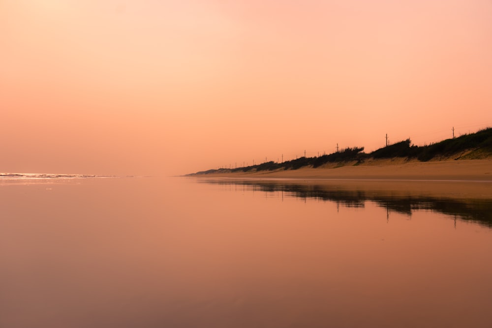 a body of water sitting next to a sandy beach