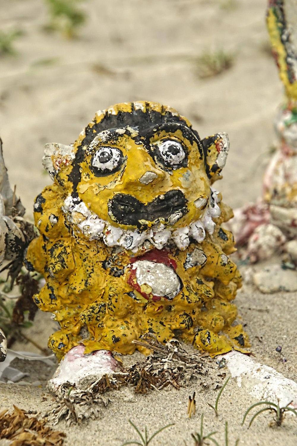 a yellow and black statue of a dog on a beach