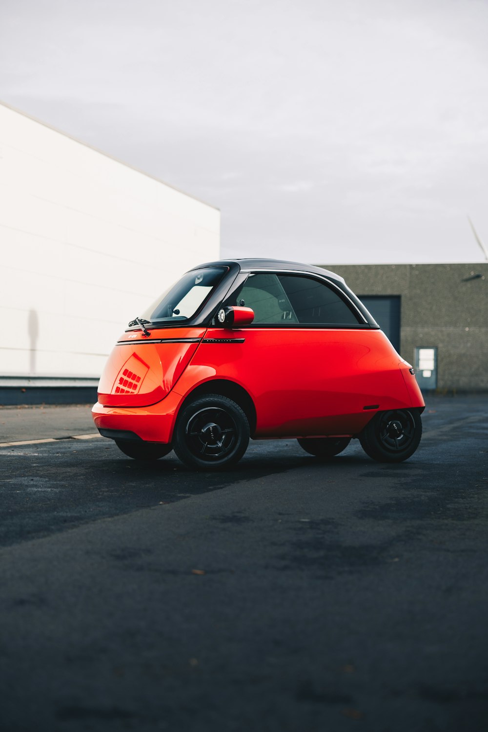 a small red car parked in a parking lot