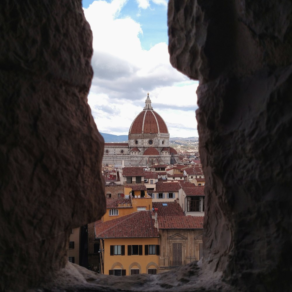 a view of a city through a hole in a wall