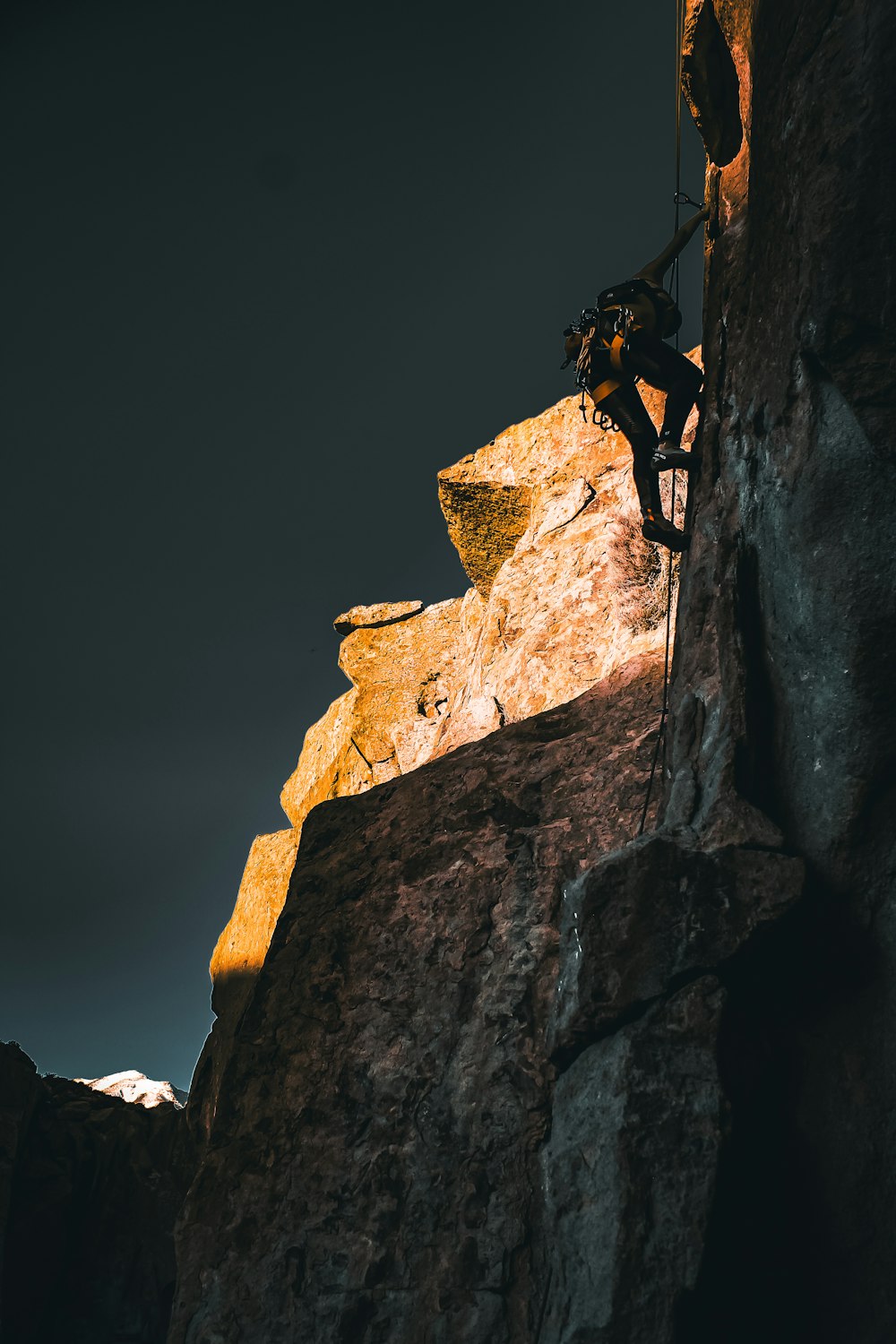 a man climbing up the side of a mountain