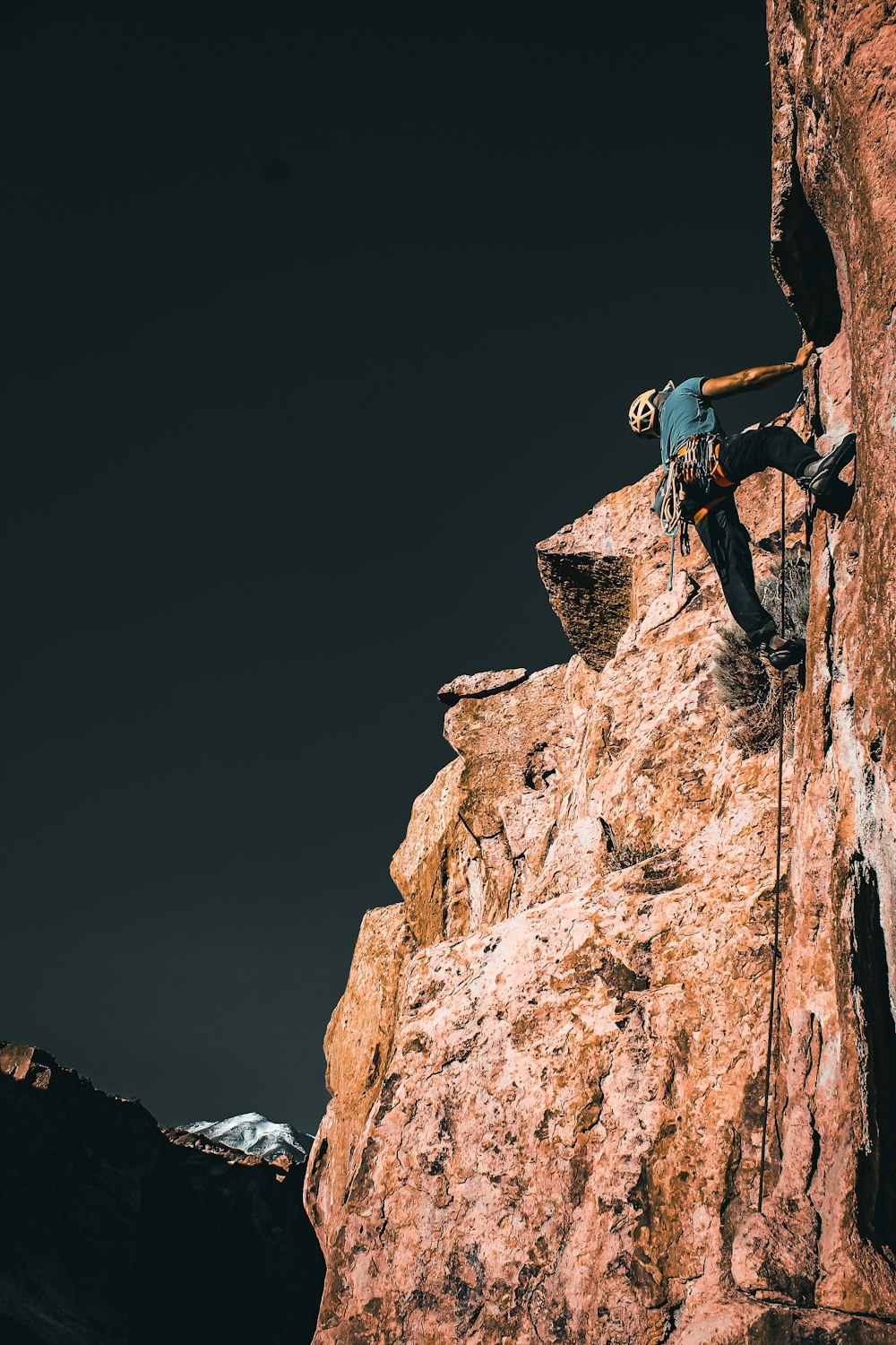 a man climbing up the side of a mountain