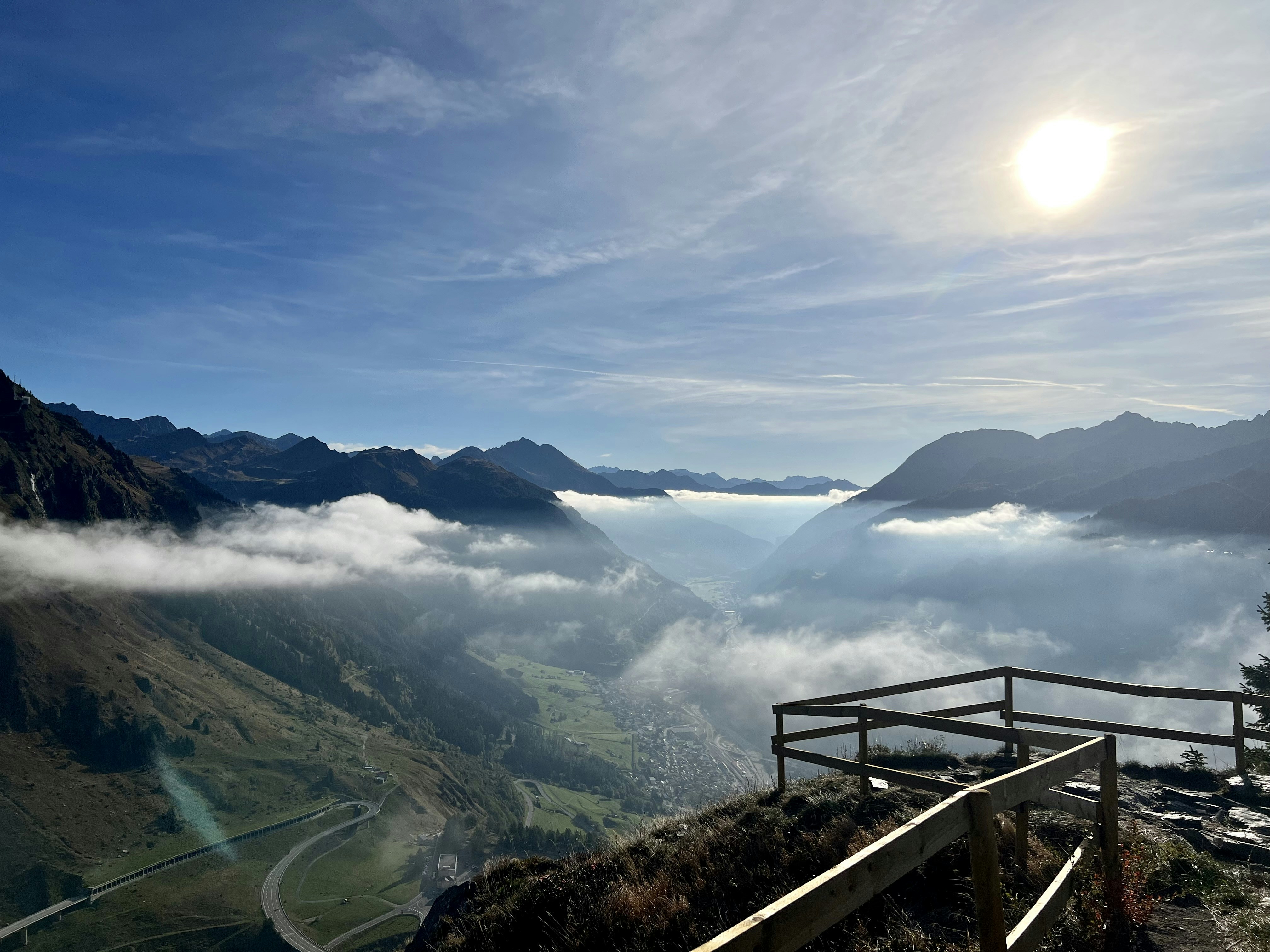 a scenic view of a mountain with clouds and mountains in the background
