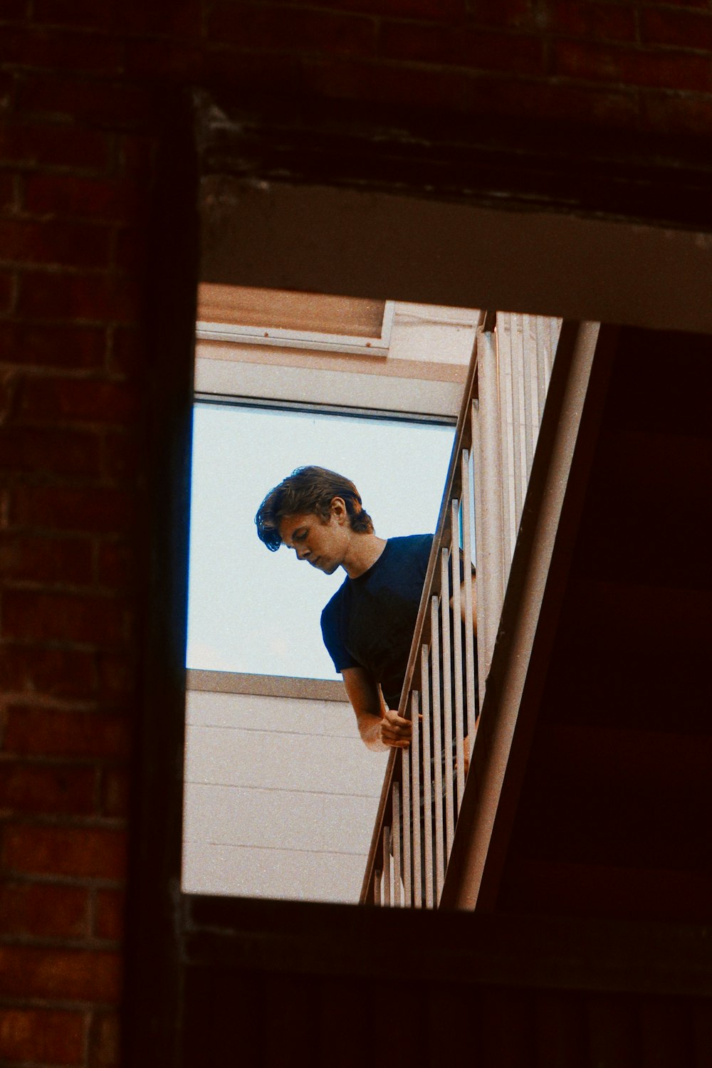 a man standing on a stair case next to a window