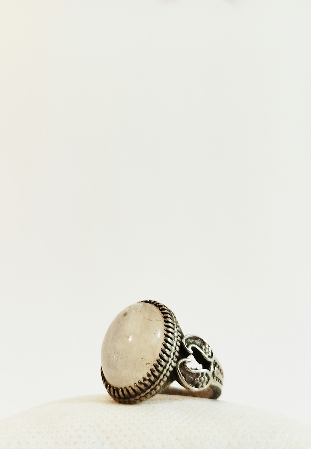 a ring with a skull on it sitting on top of a pillow