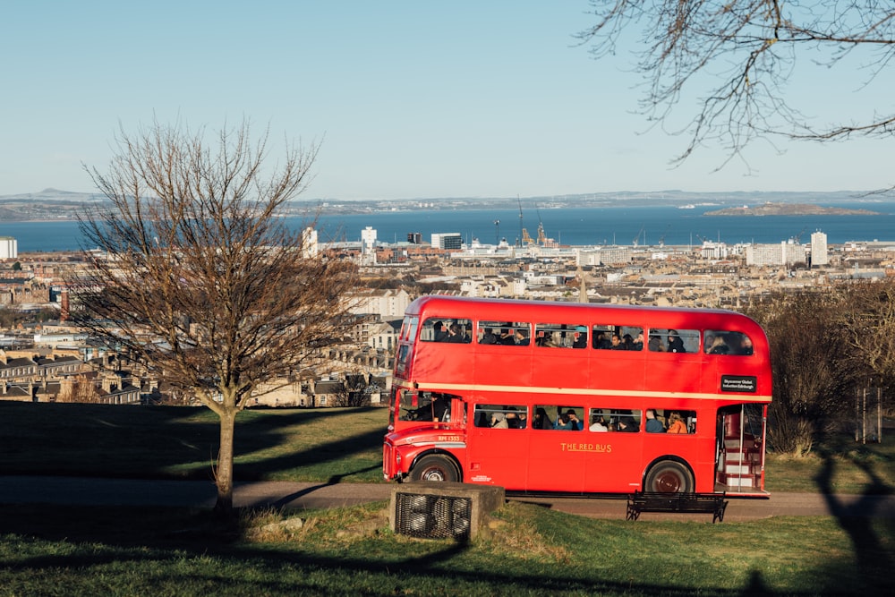 a red double decker bus driving down a road