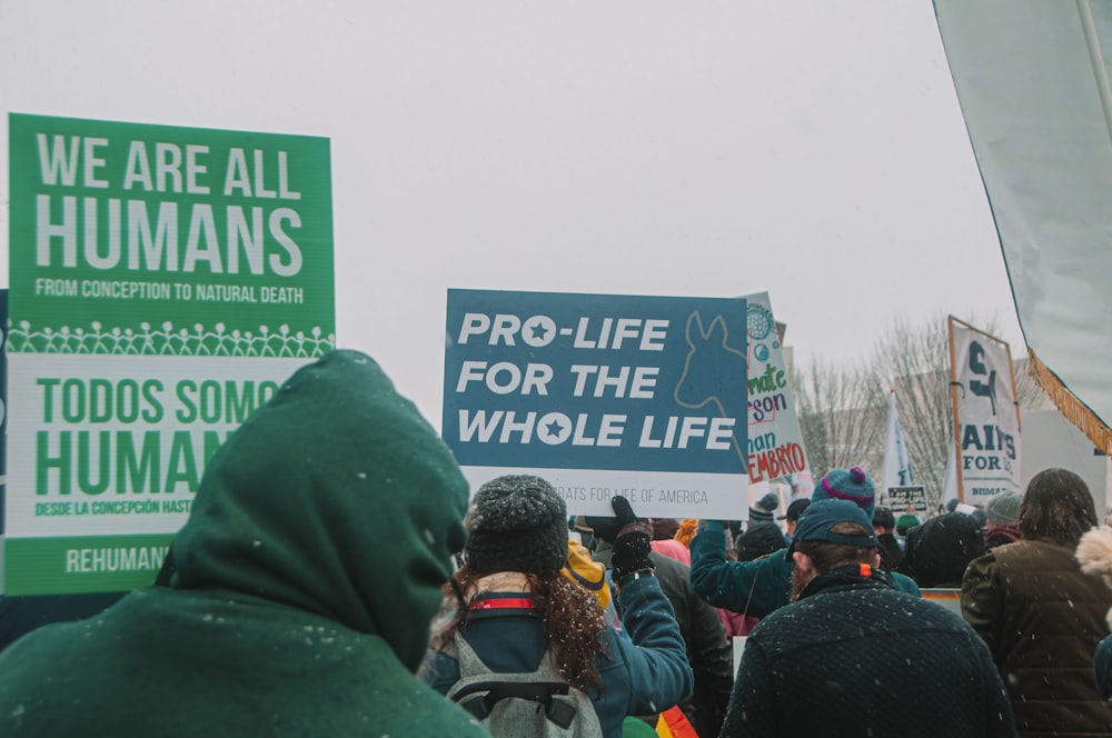 a group of people holding up signs in front of a crowd