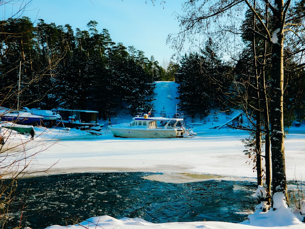 a boat on a frozen lake in a wooded area