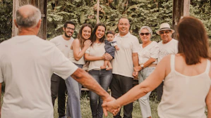a group of people holding hands in front of trees