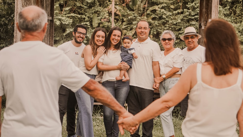 a group of people holding hands in front of trees
