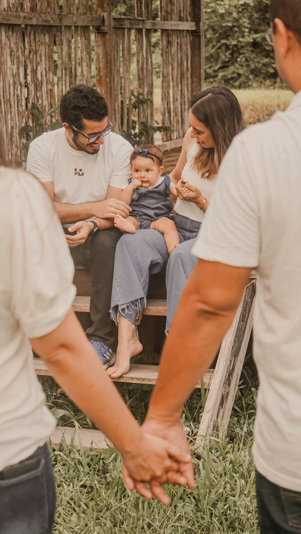 a group of people sitting on a bench holding hands